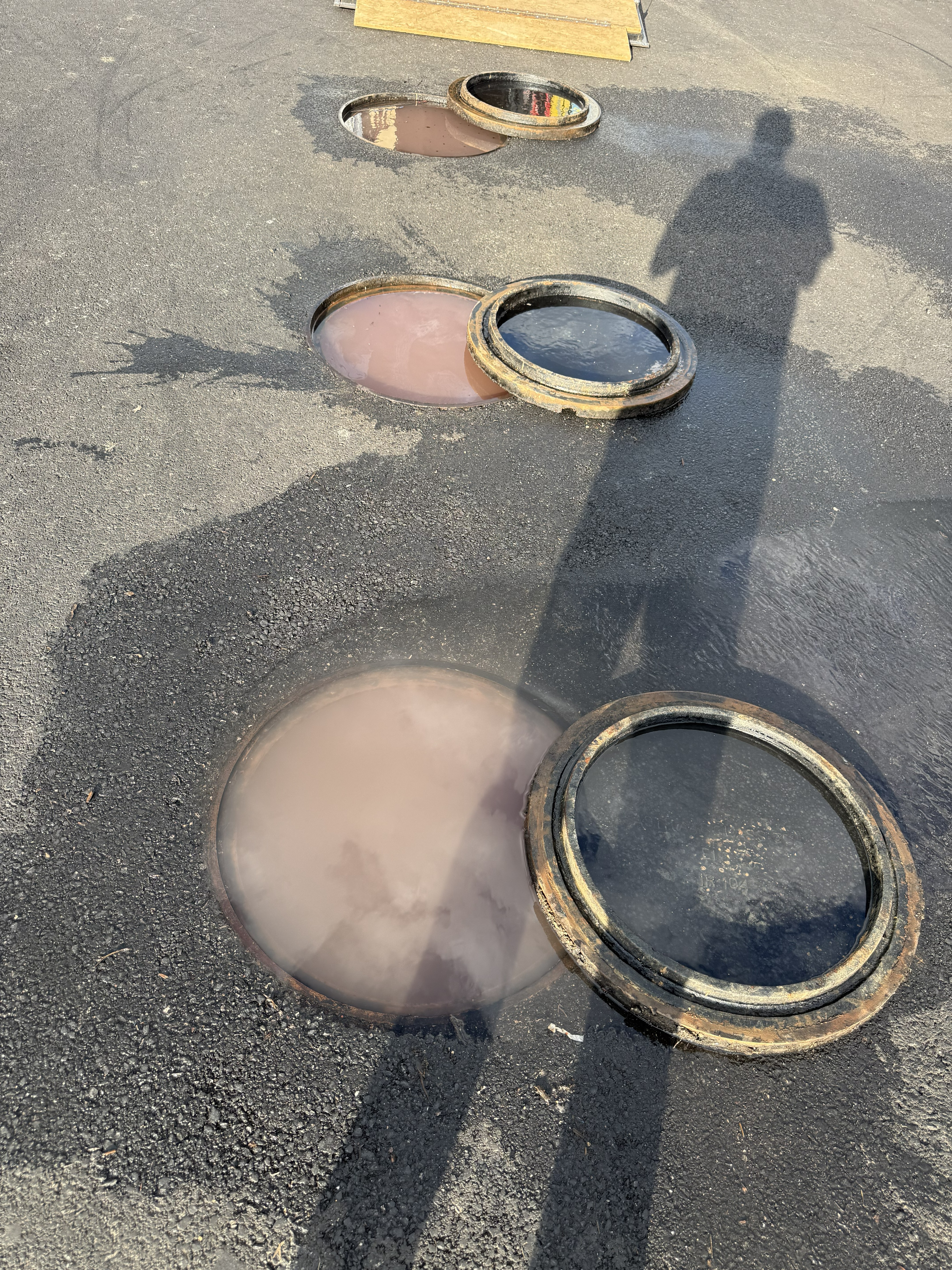 Car wash parking lot drains overflowing — wastewater backing up to the surface