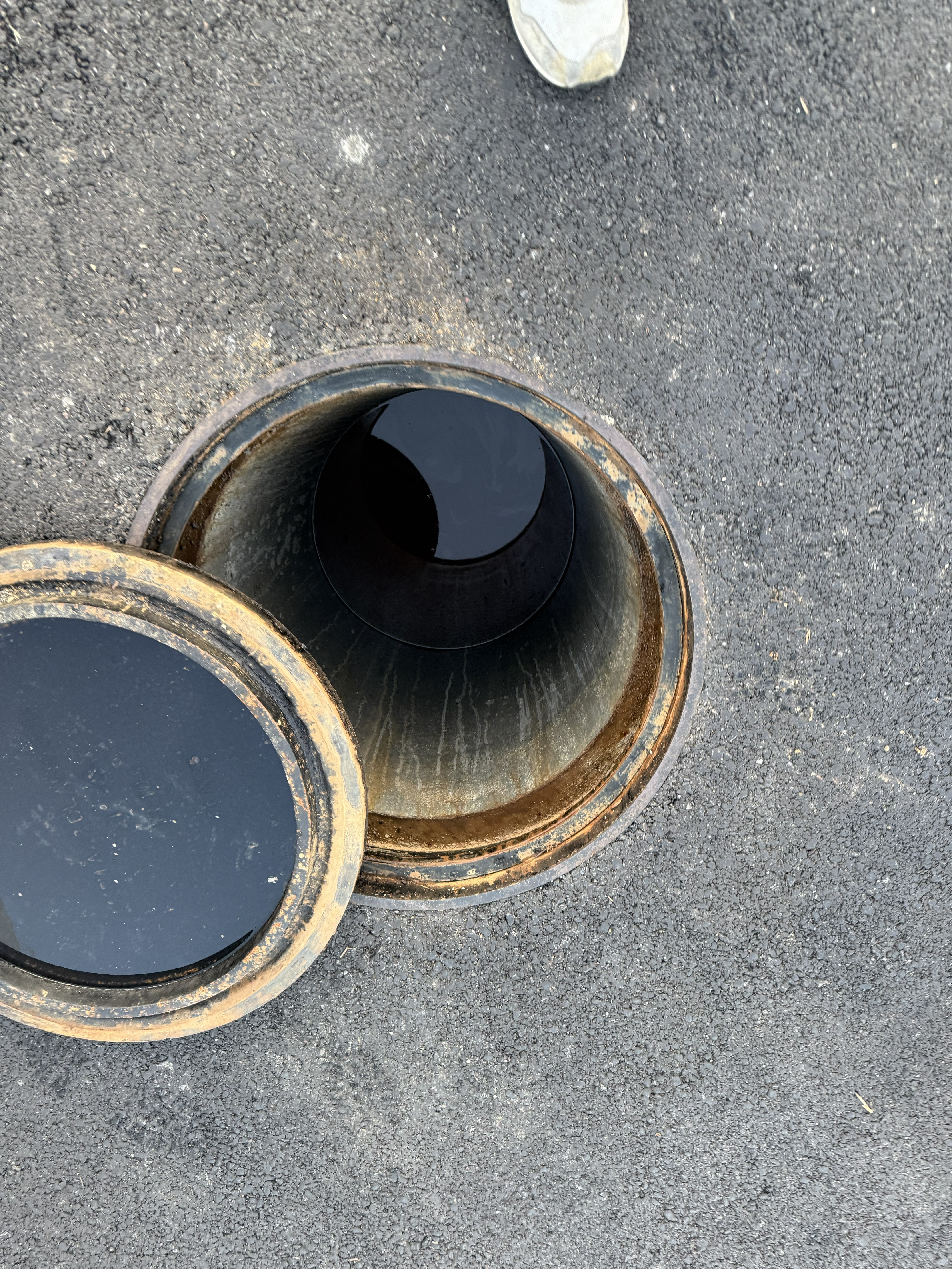 Open drain showing water level before clearing — system completely backed up