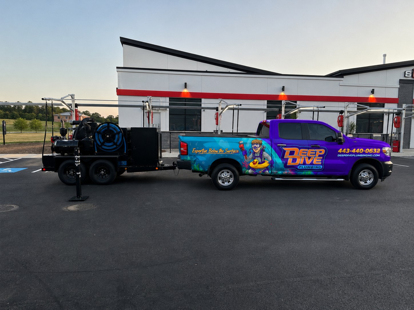 Deep Dive Plumbing truck and hydro jet trailer on site at the car wash — ready to work